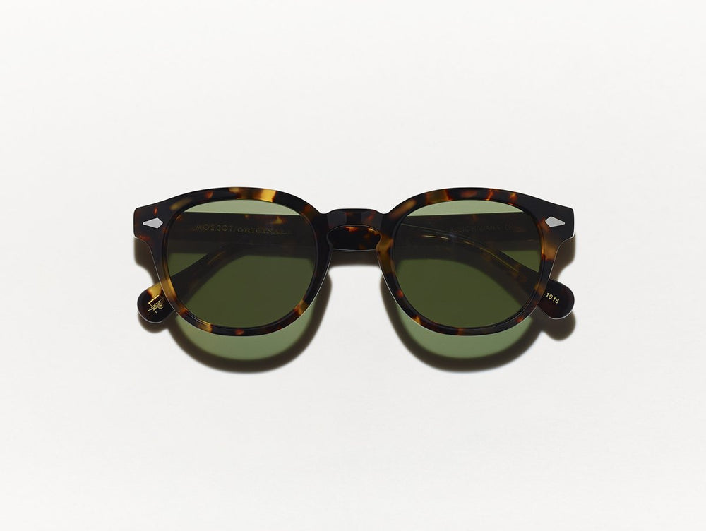 Polished black and yellow tortoiseshell MOSCOT Lemtosh Sunglasses with green glass lenses front view