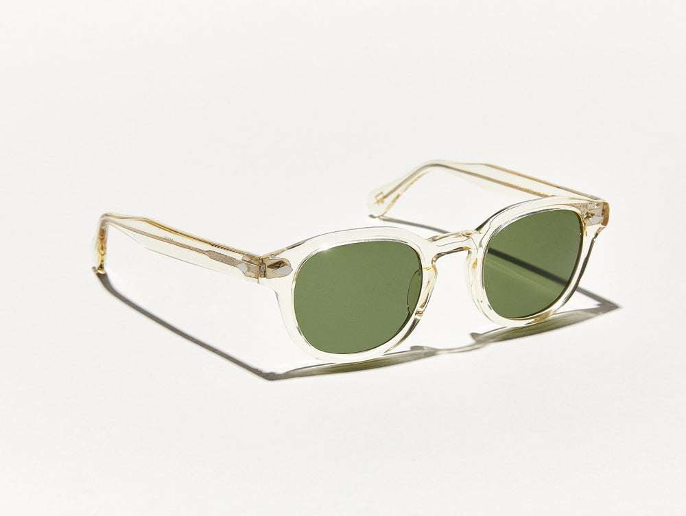 
                
                    Load image into Gallery viewer, Polished slightly yellow toned transparent acetate MOSCOT Lemtosh Sunglasses with green lenses side view
                
            