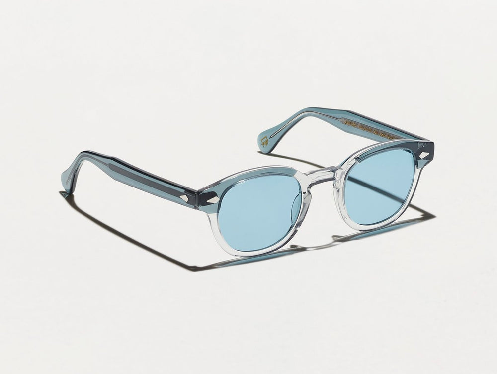 
                
                    Load image into Gallery viewer, Polished light grey and blue acetate MOSCOT Lemtosh sunglasses with light blue glass lenses side view
                
            