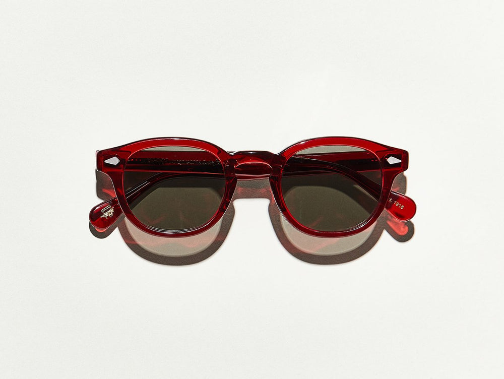 Semi transparent ruby red polished acetate MOSCOT Lemtosh sunglasses with grey glass sunglass  lenses front view